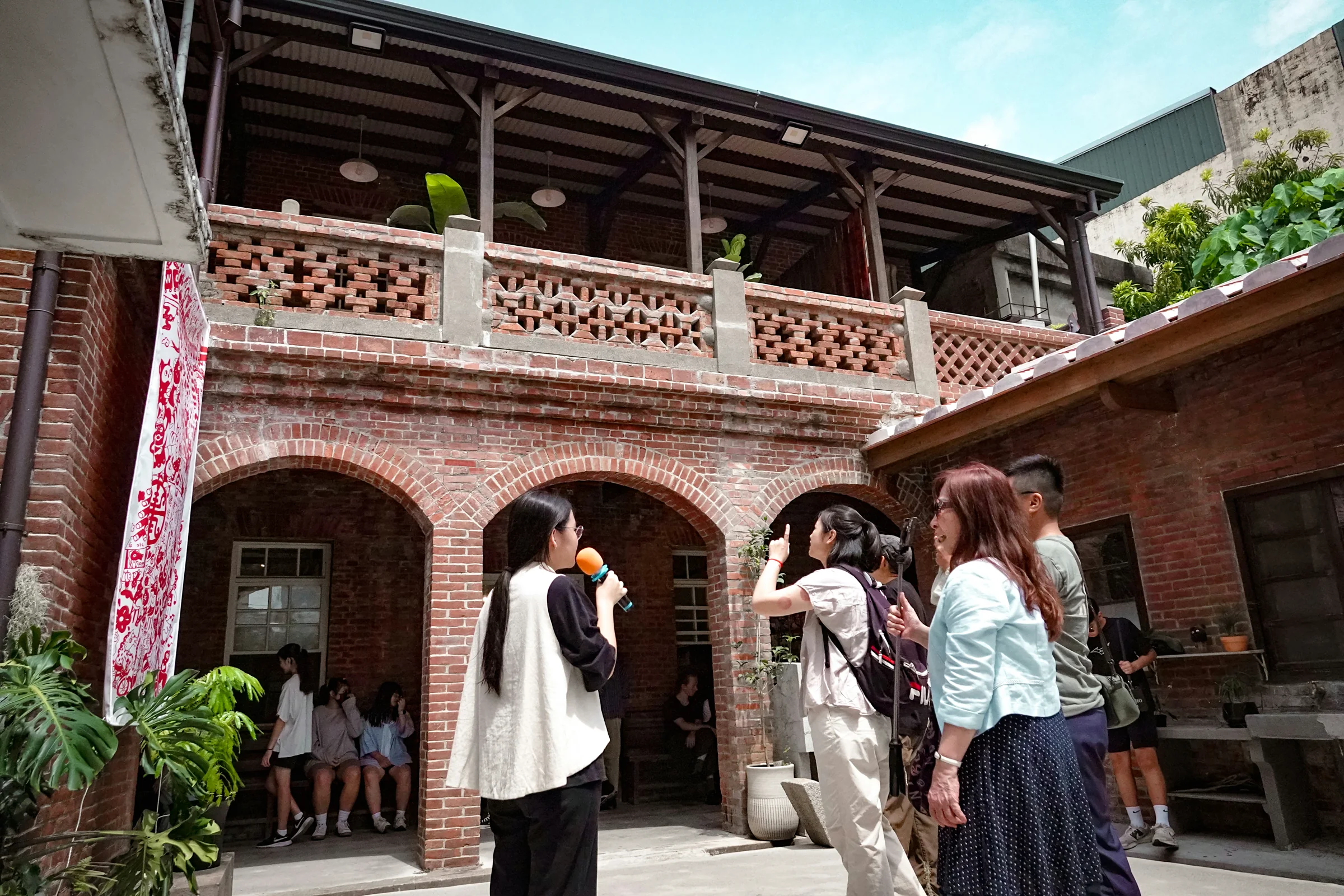 遊客在雲林土庫萬得醫院紅磚院落參加老建築與醫療記憶深度導覽